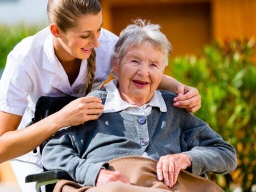 Older lady in a wheelchair with her carer