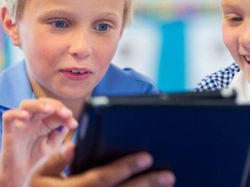 Boy interacting with a tablet in a classroom