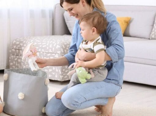 Childminder playing with a baby in her home.