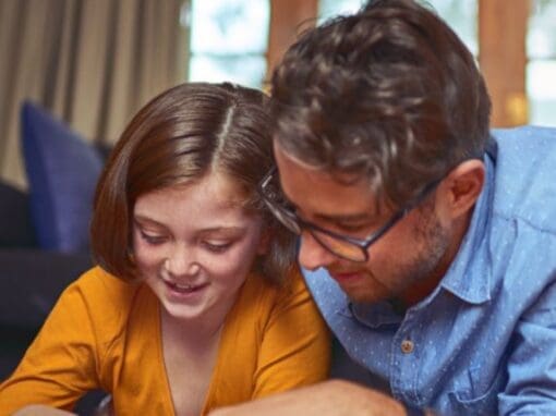 Father and daughter looking at at tablet in their home.