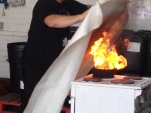 Fire Trainer demonstrating the use of a fire blanket