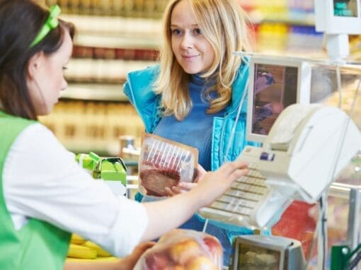 Checkout lady in a supermarket serving a woman customer.