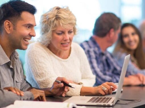 Two teachers looking at something on a computer.