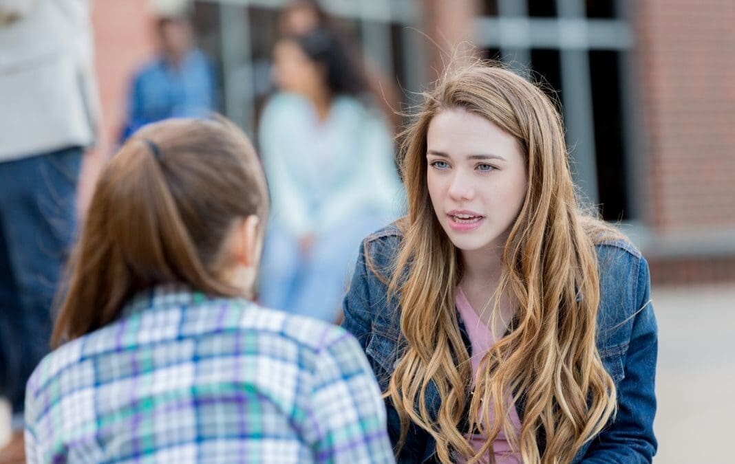 A girl shares a safeguarding concern with another girl.