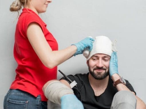 A lady doing a head bandage in a first aid course