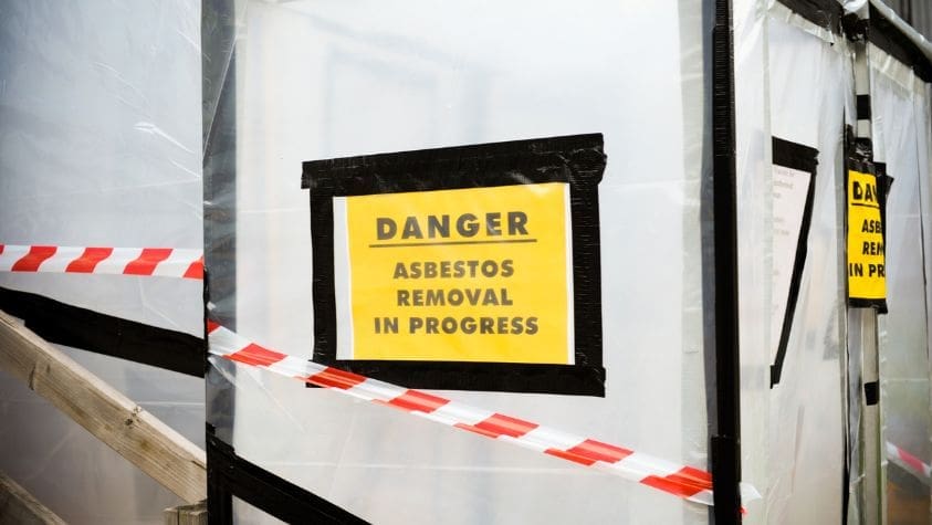 A warning notice about a building that is having asbestos removed