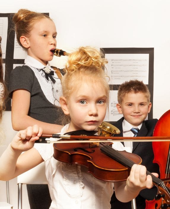 School children playing musical instruments.